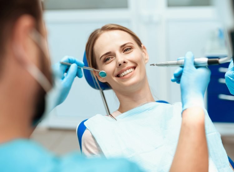 woman-sits-dental-chair-doctors-bowed-her